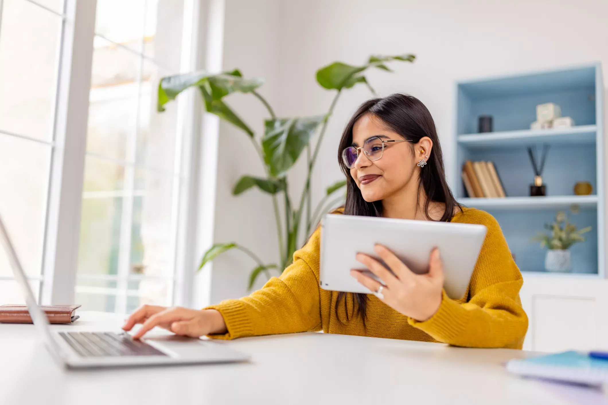 Happy woman uses electronic devices at home with fast internet